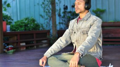 A man wearing headphones while meditating