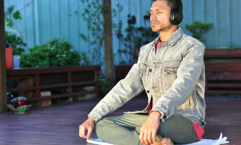 A man wearing headphones while meditating